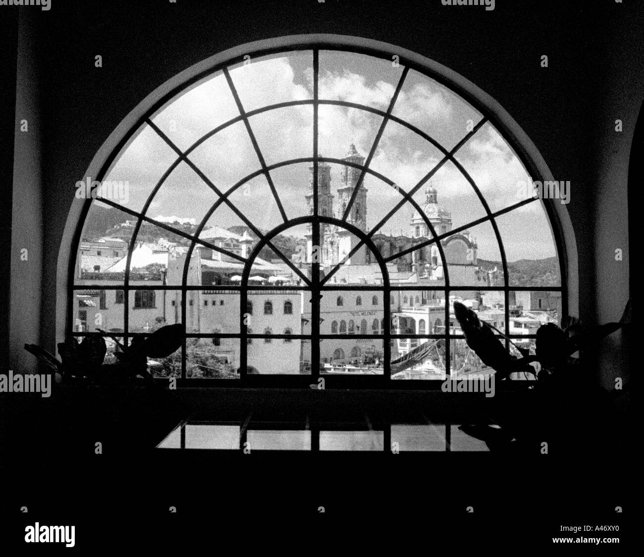 An arched window with a Mexican city in the background Stock Photo