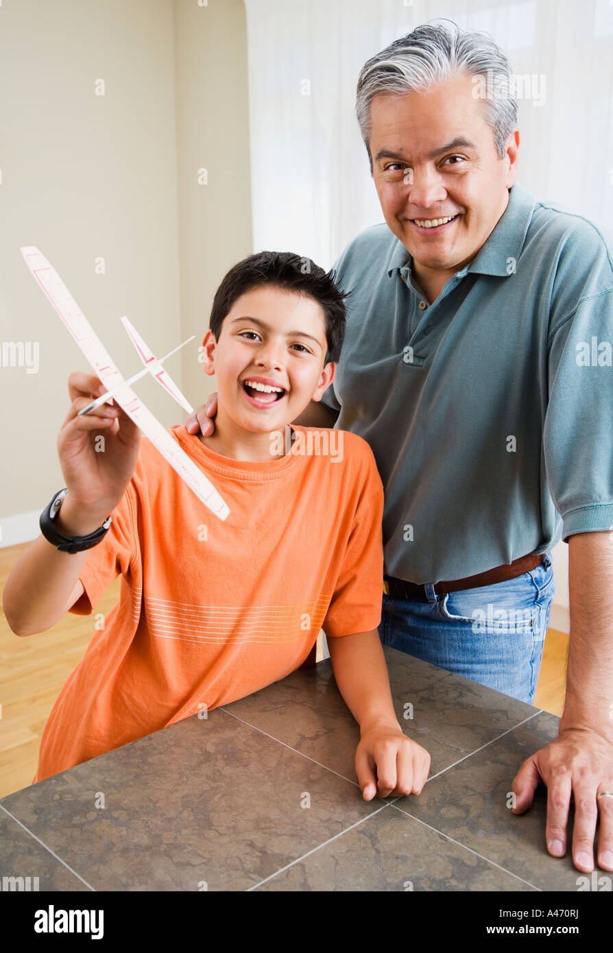 Hispanic father and son holding model airplane Stock Photo - Alamy