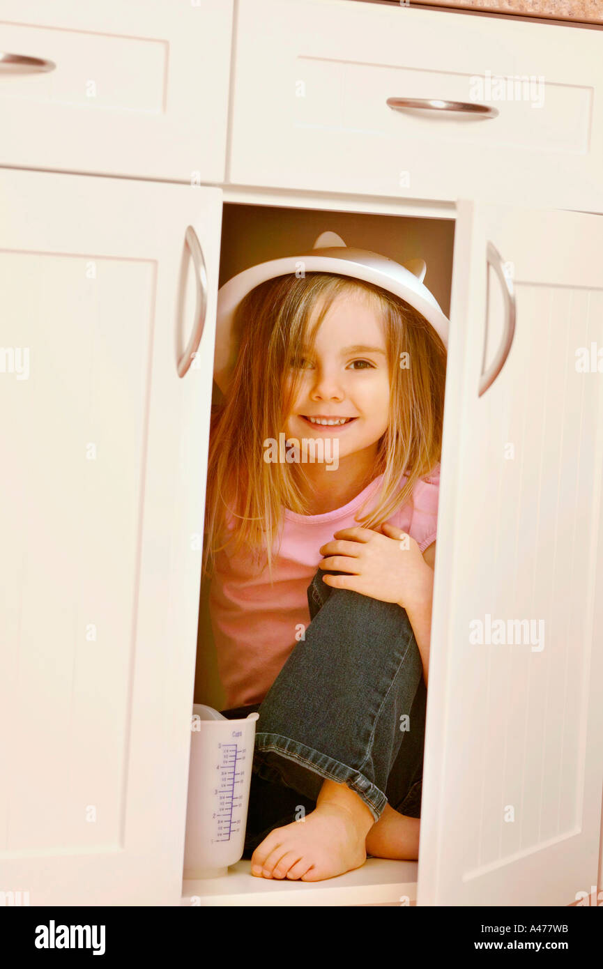 Child hides in kitchen cupboard Stock Photo Alamy