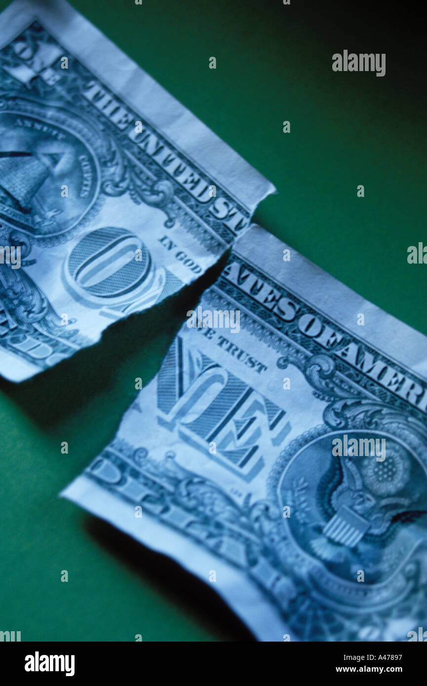 Torn dollar bill exhibiting a weakness in the economy or the US dollar Stock Photo