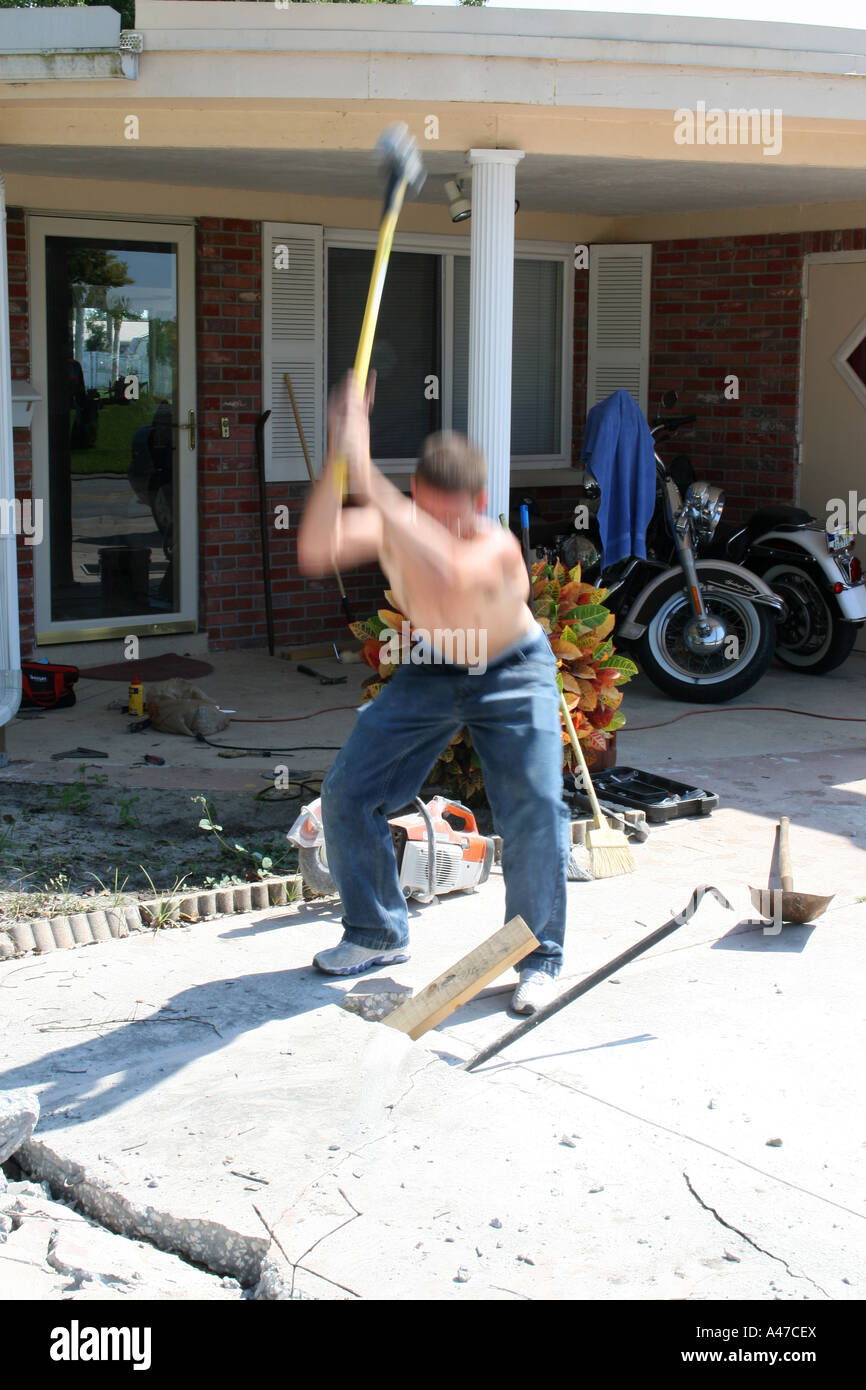 Young Man Breaking a Concrete Slab with a Sledge Hammer Stock Photo Alamy