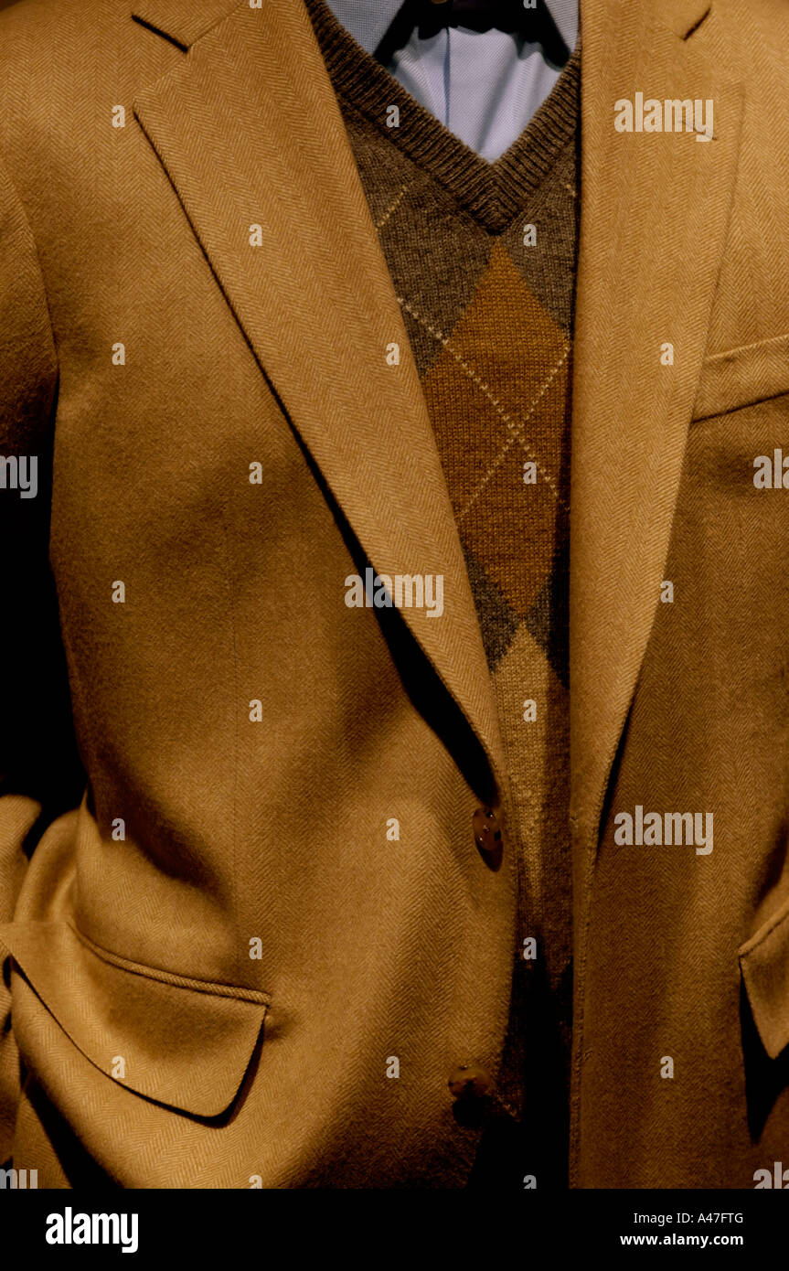 Store window mannequin wearing camel tan blazer and a plaid diamond pattern v-neck sweater Stock Photo