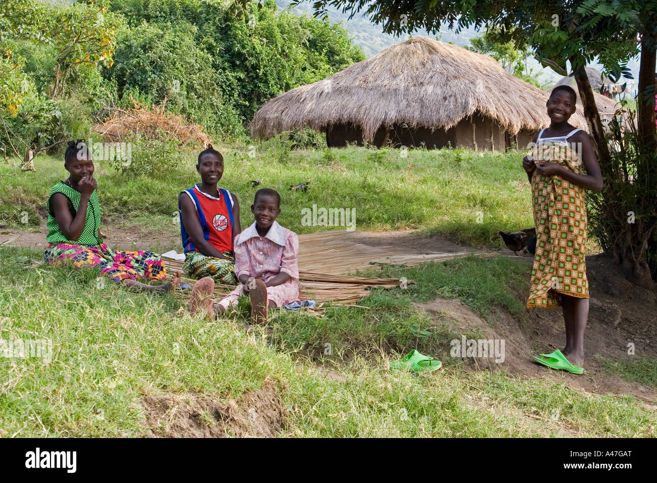 Three women and girl in remote village on shores of Lake Albert, Northern Uganda, East Africa Stock Photo