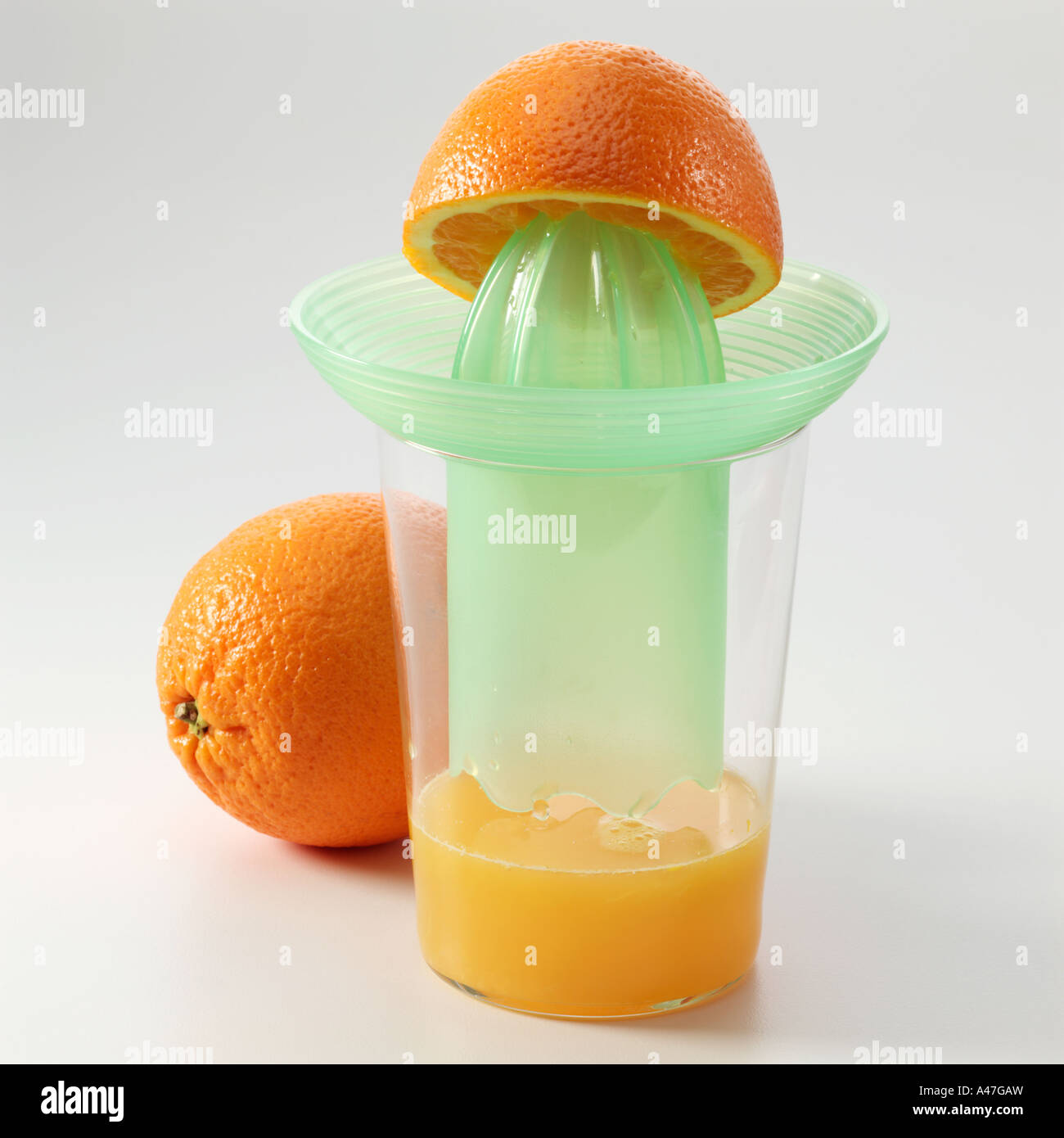 Half an orange on a juicer with orange juice on a white background editorial food Stock Photo