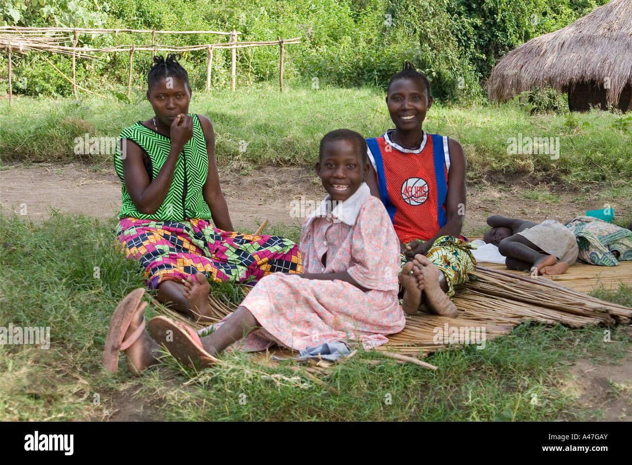 Two women with boy and girl in remote village on shores of Lake Albert, Northern Uganda, East Africa Stock Photo