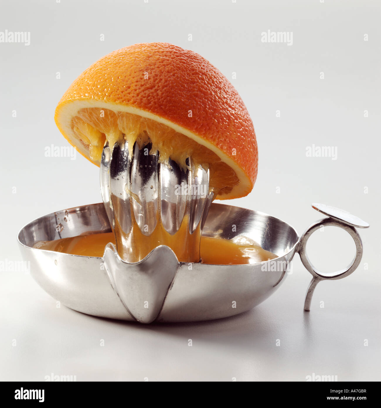 Half an orange on a metal juicer on a white background editorial food Stock Photo