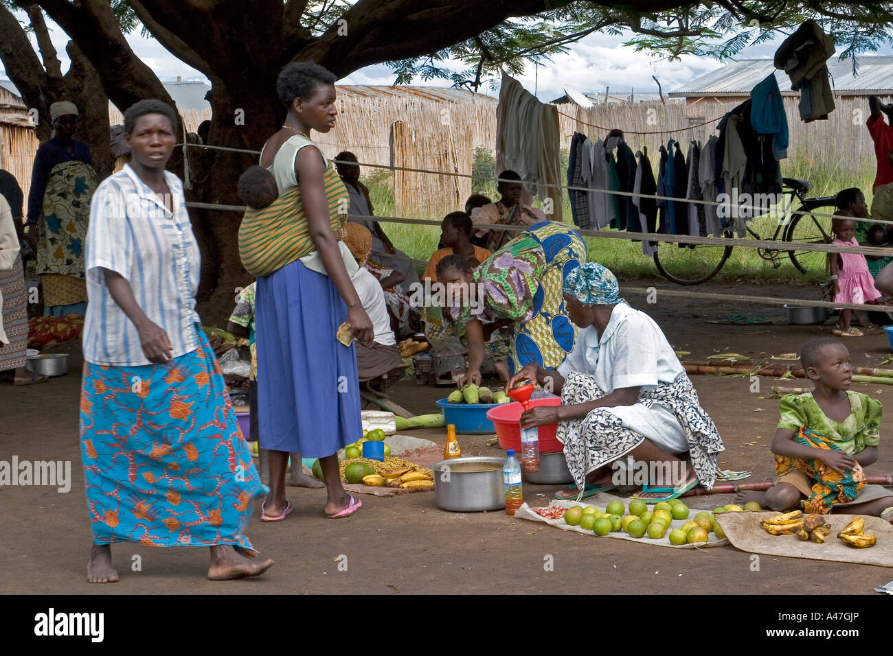 Local women buying and selling fruit in market of remote fishing village, Lake Albert, Northern Uganda, East Africa Stock Photo
