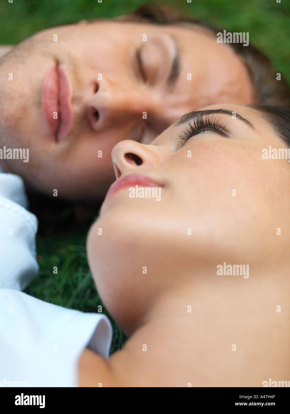 Young couple sleeping in field Stock Photo