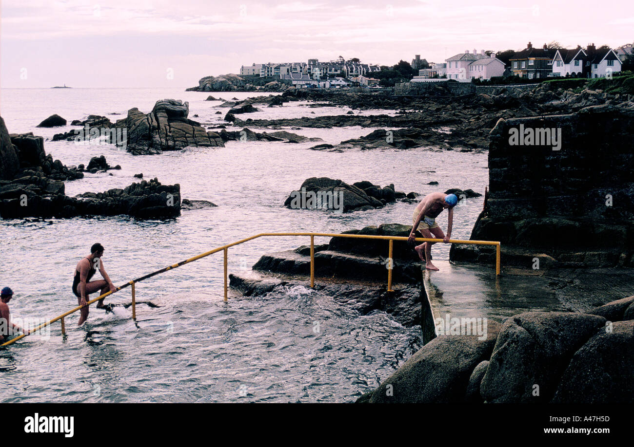 Swimmers climbing out of the freezing water at the 40 ft bathing hole at Sandy Cove near Dublin Stock Photo