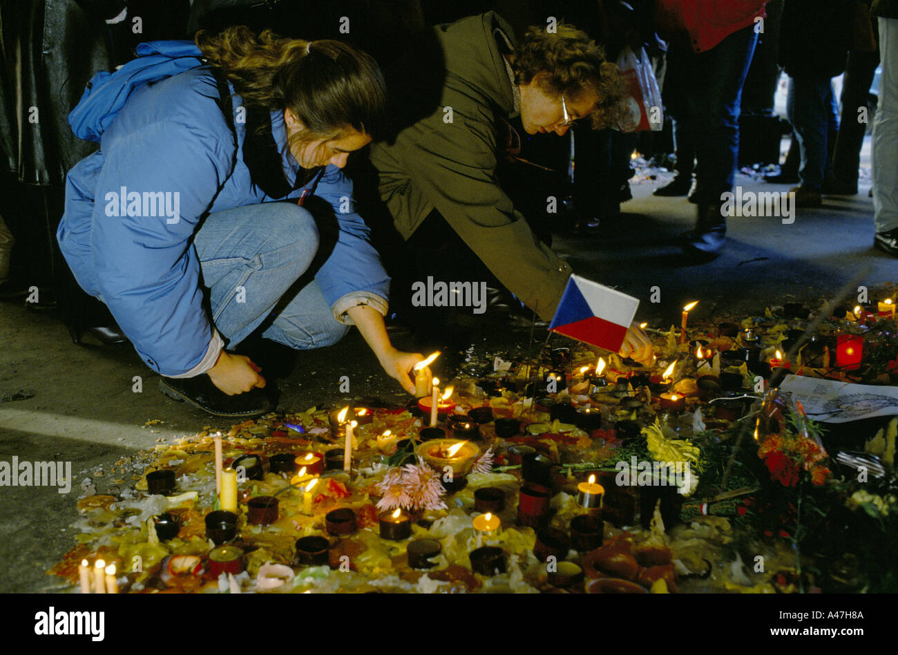People lighting candles in Prague at the place where police killed a student demonstrating against the communist regime Stock Photo
