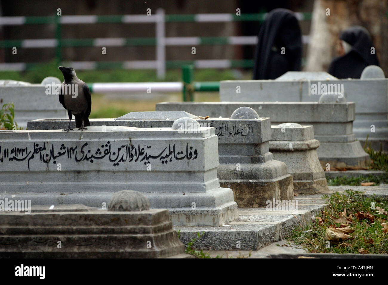 Women converse in a graveyard in Srinagar in Kashmir in India Stock Photo
