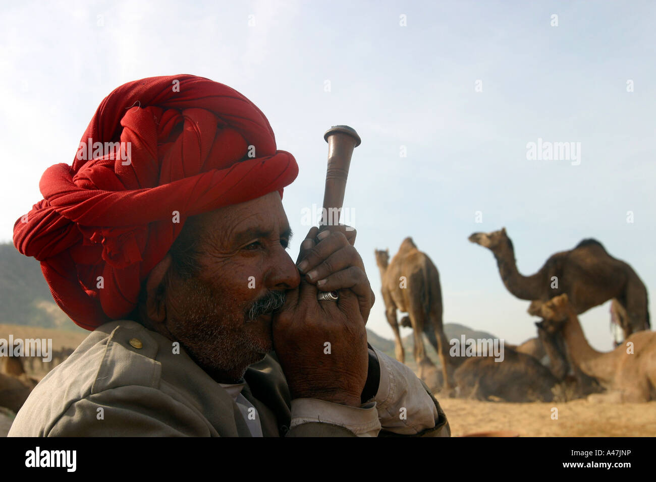 A man smokes on a pipe during the annual Pushkar Camel Fair in India Stock Photo