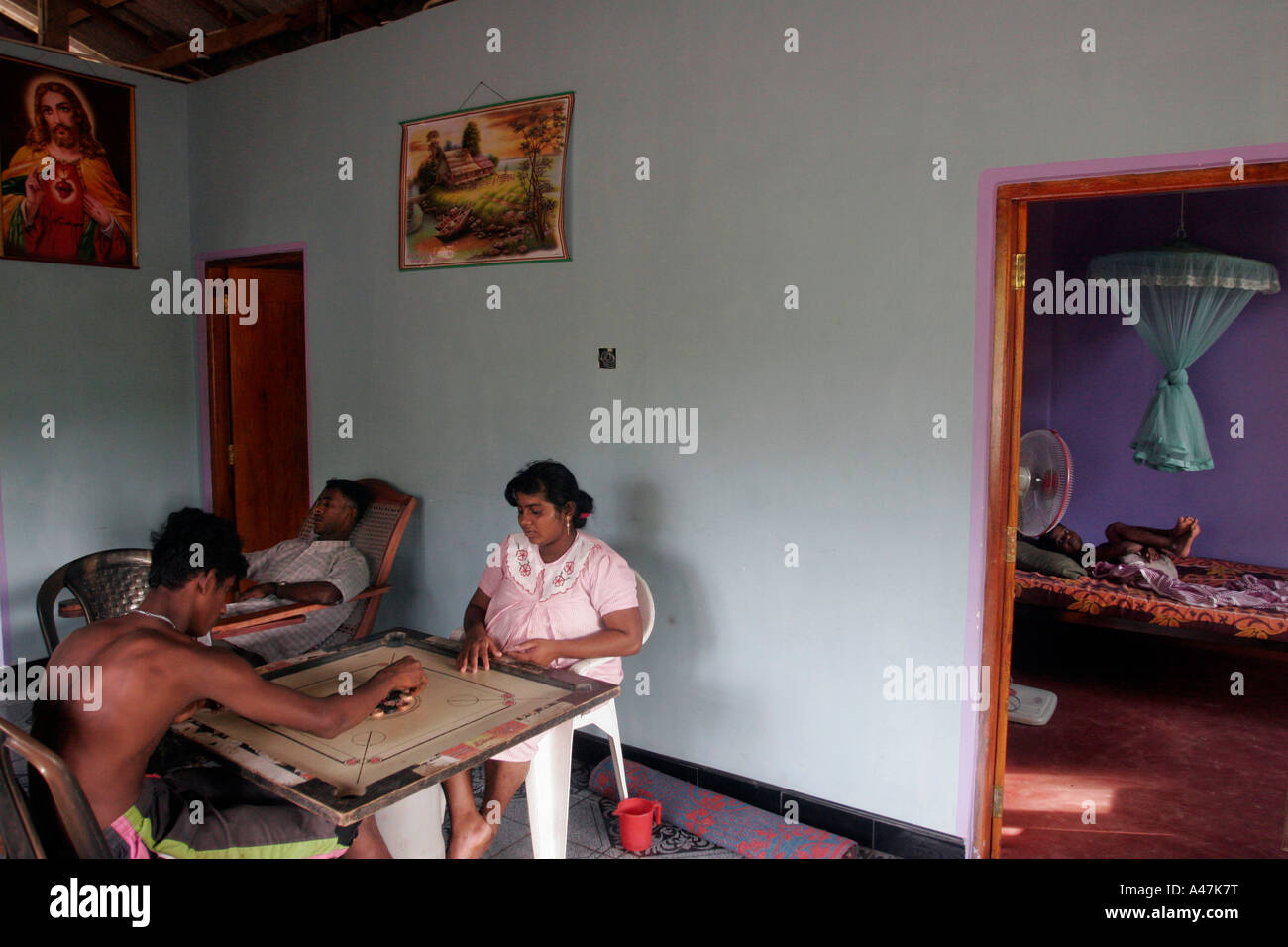 A family who lost their home in the tsunami sits in the living room of their new house in the village of Godagama in Sri Lanka Stock Photo