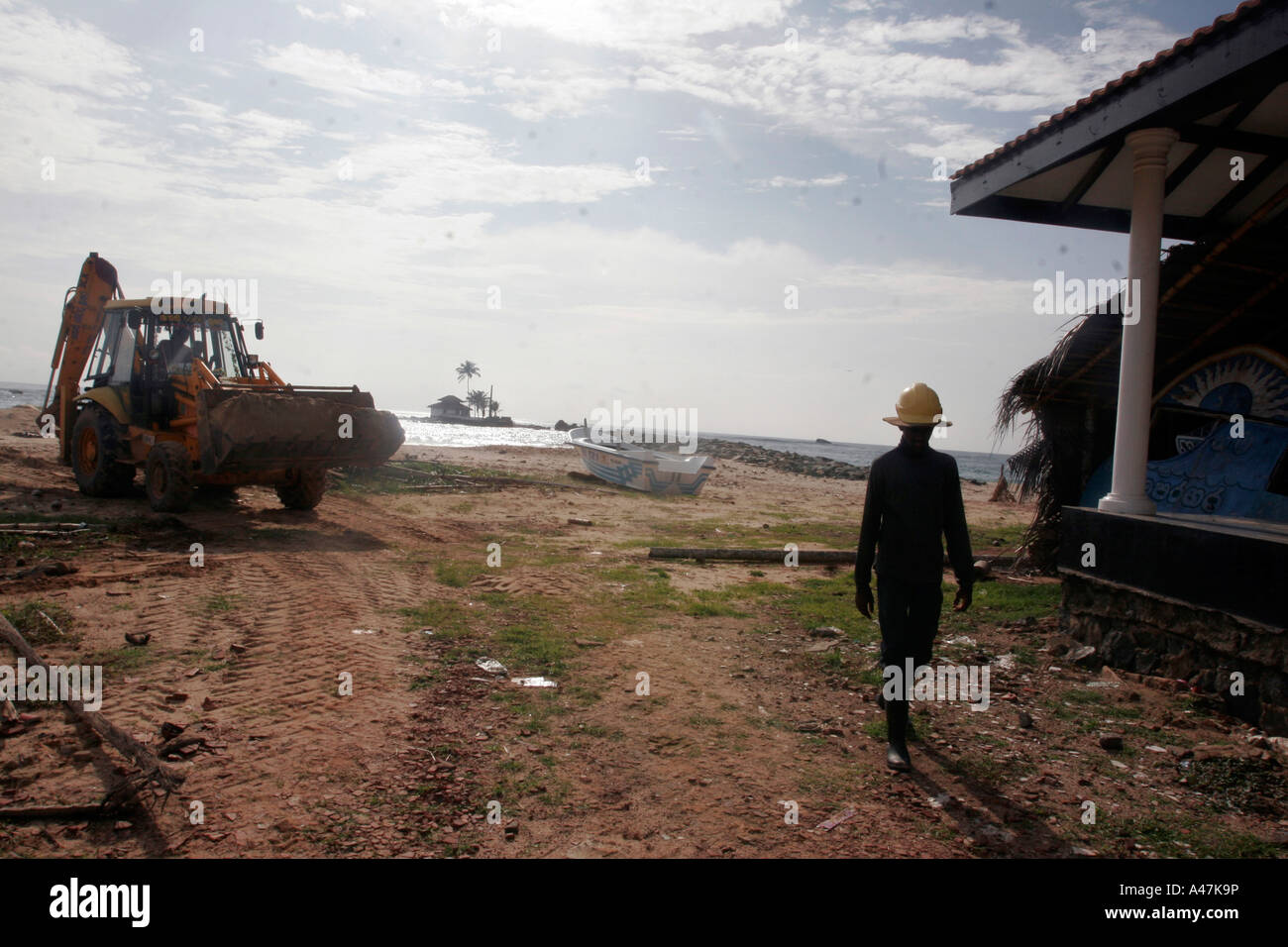 A construction worker walks on the beach near the village of Paraliya ...