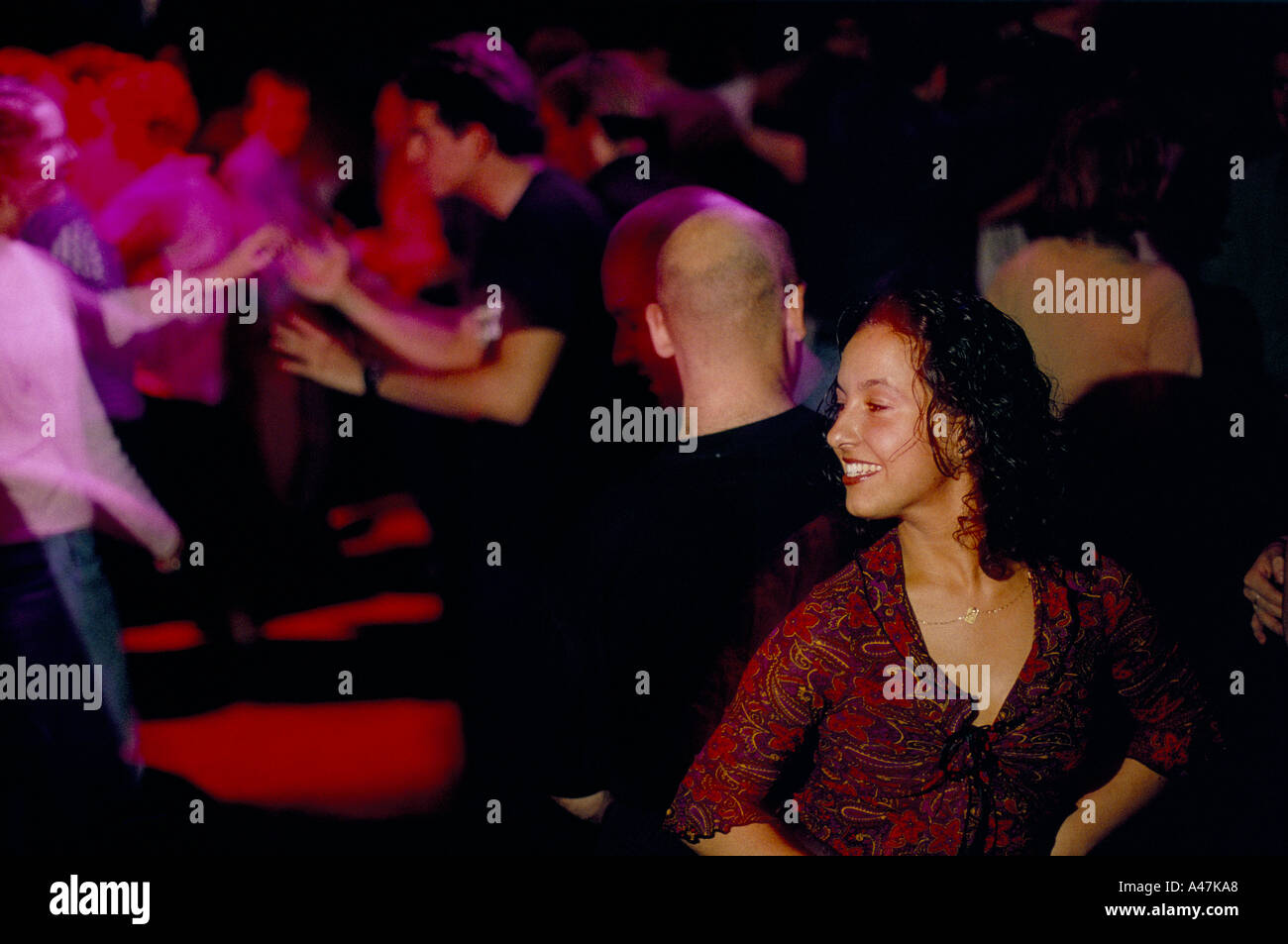 a woman turns and smiles at a busy salsa bar in dublin Stock Photo Alamy