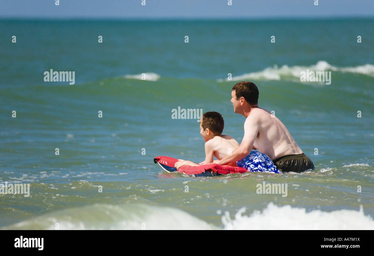 Father and son in Atlantic Ocean with raft Stock Photo