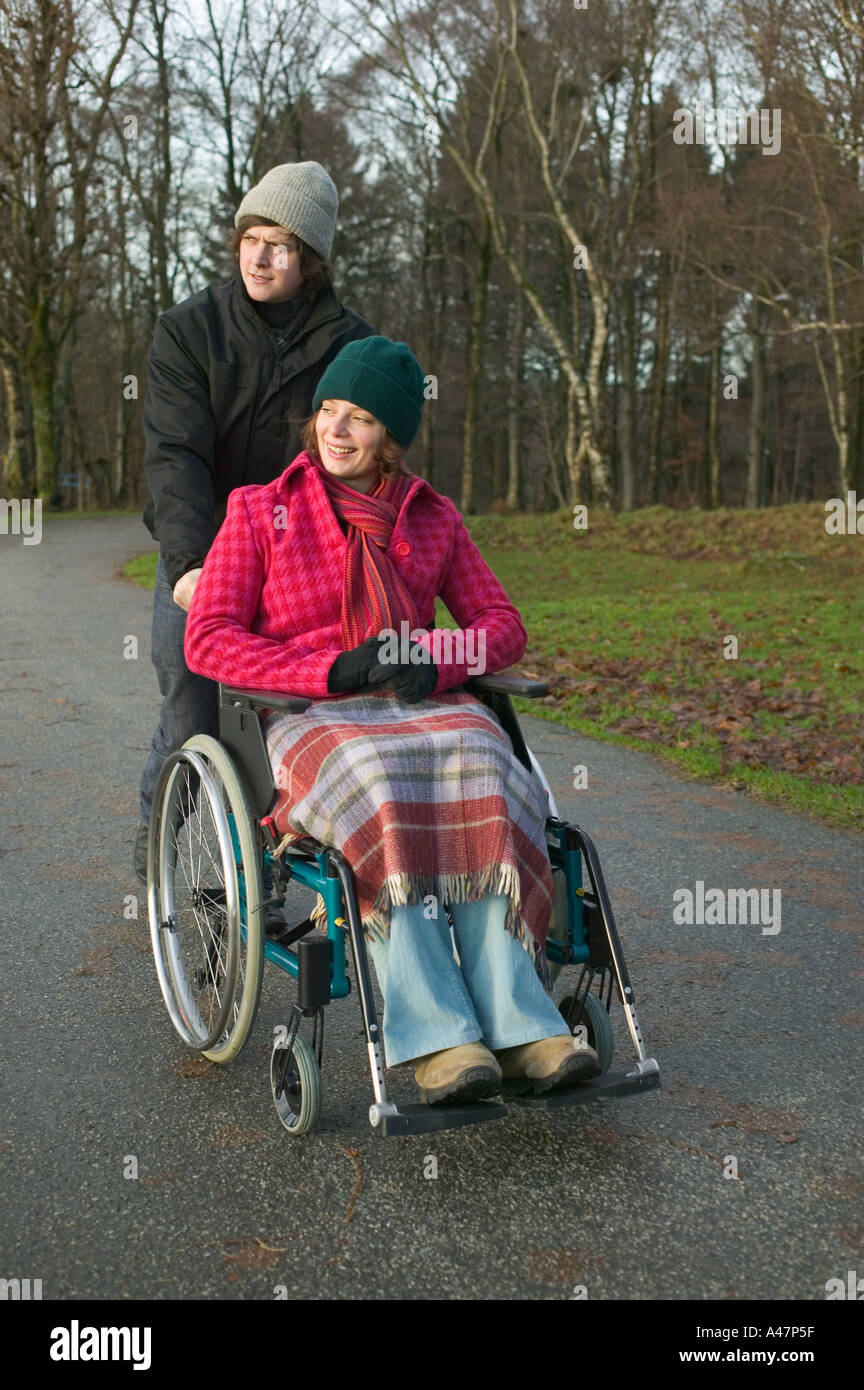 Disabled woman and partner in park Stock Photo