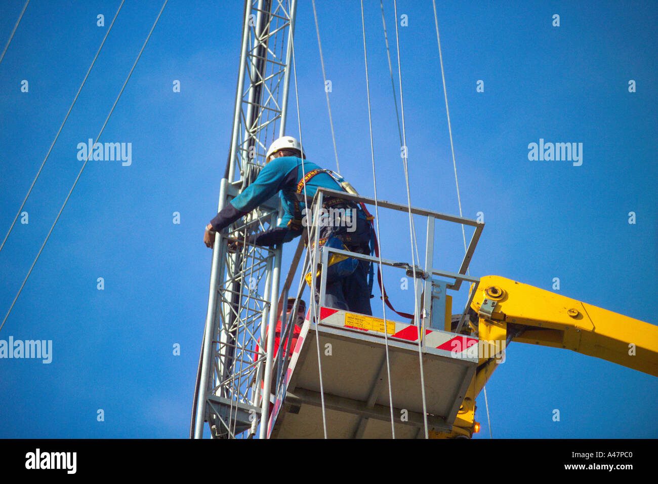 Man on crane working on mast Stock Photo Alamy