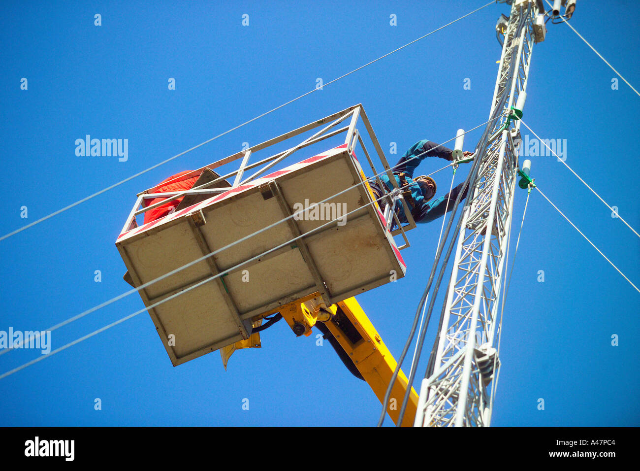 Man on crane working on mast Stock Photo - Alamy