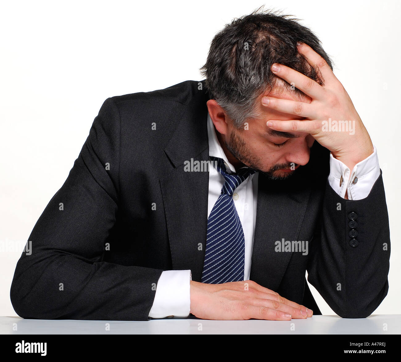 An emotional man sits holding his head with his hands. Picture by ...