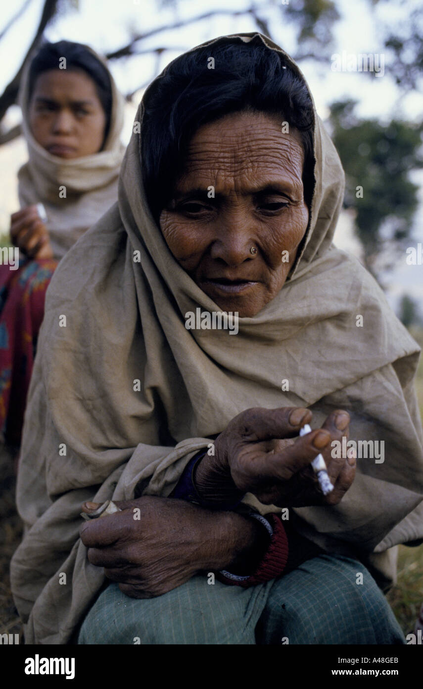 nepalese women wrapped up aginst the cold in the mountains and smoking cigarettes. Stock Photo
