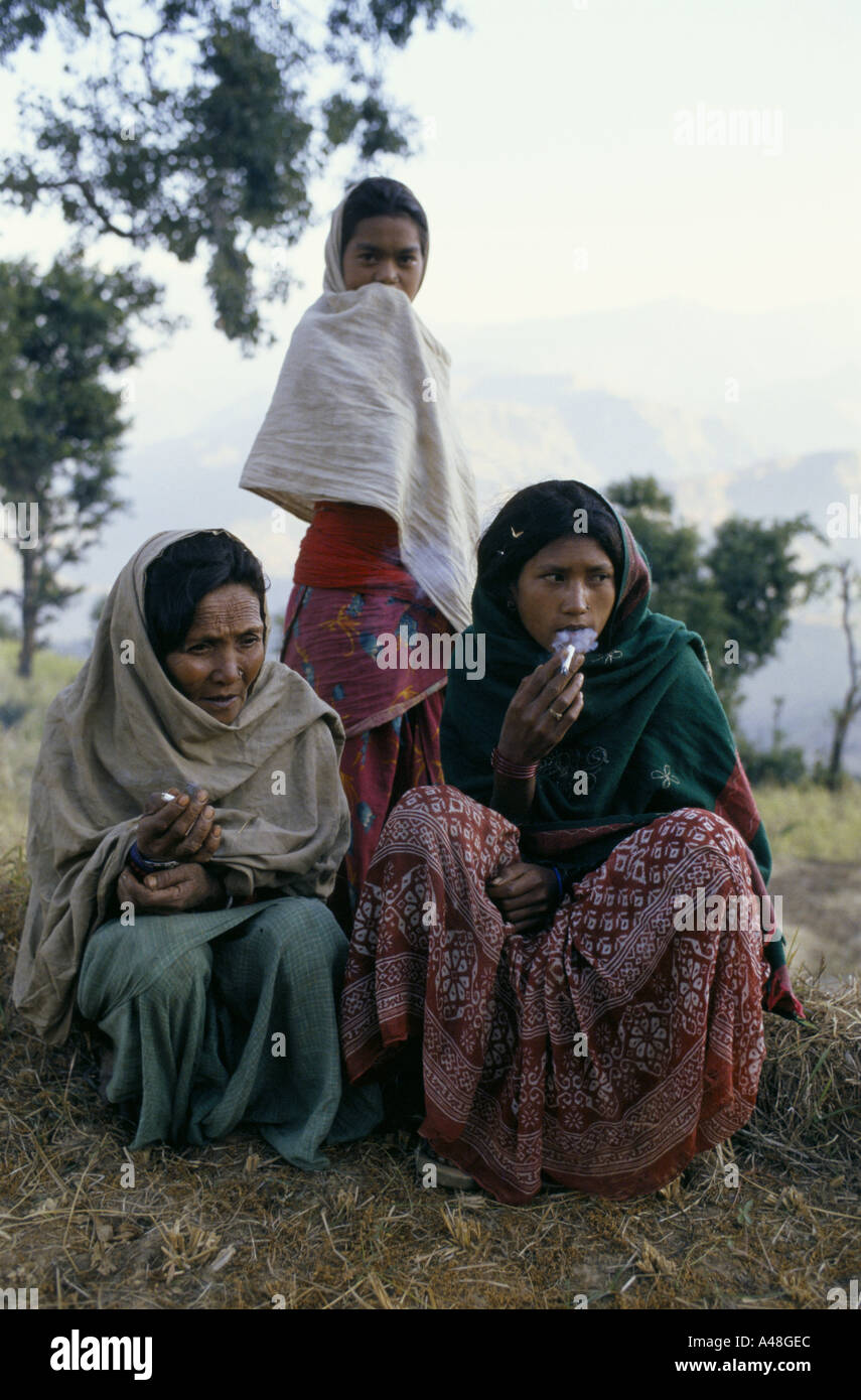 Two nepalese women wrapped up aginst the cold in the mountains and smoking cigarettes. Stock Photo