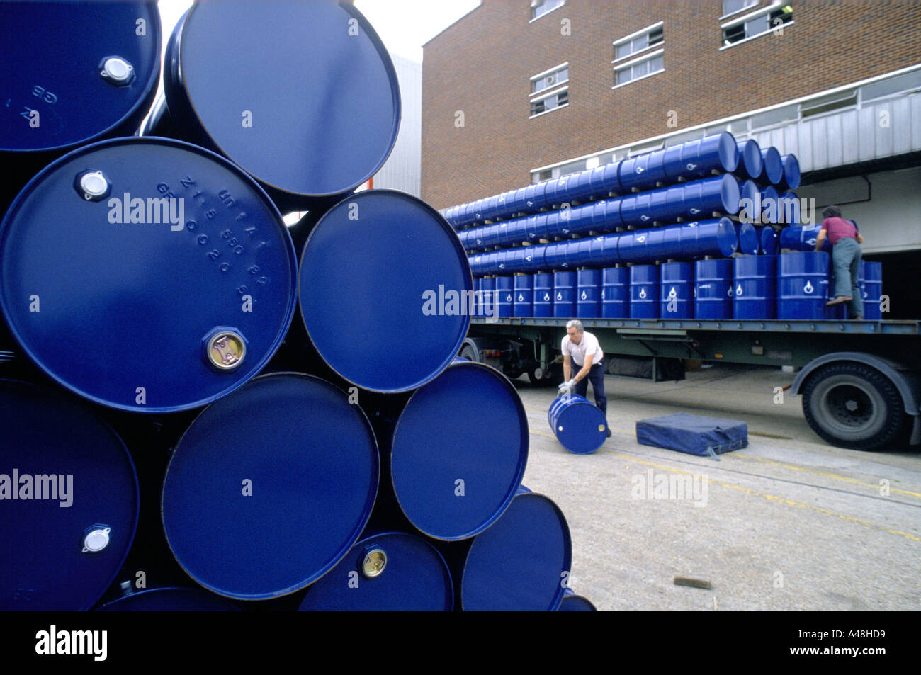 workers of perfume industry rolling cylindrical tanks of concentrated essences for dispatching to manufacturer perfume Stock Photo