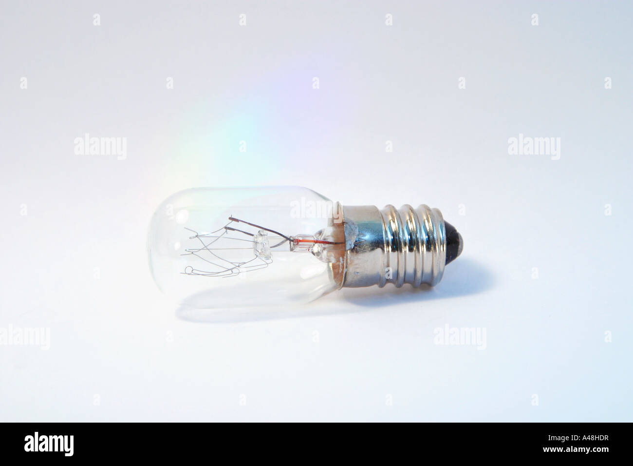 Small screw in light bulb on its side against a plain white background Stock Photo
