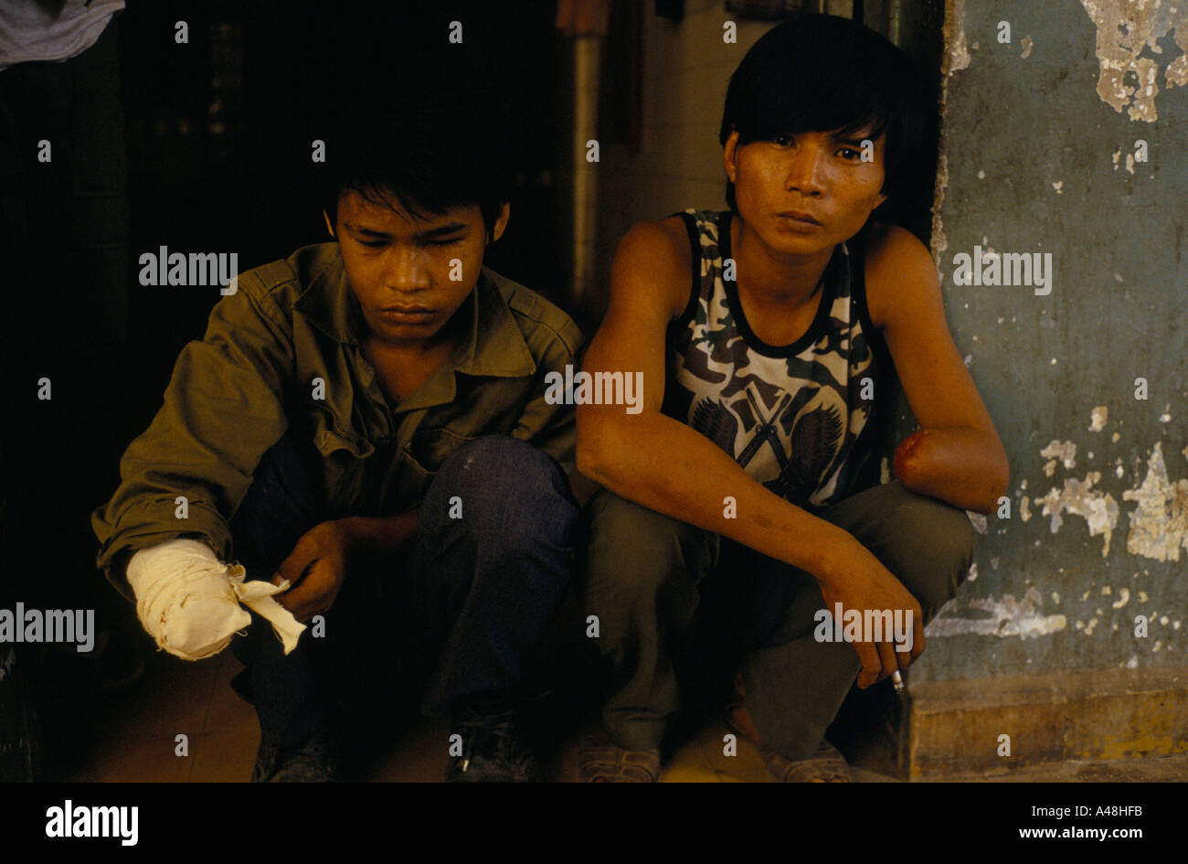 victims of mines laid during civil war in Cambodia sit hopelessly  in a hospital in Phnom Penh Stock Photo