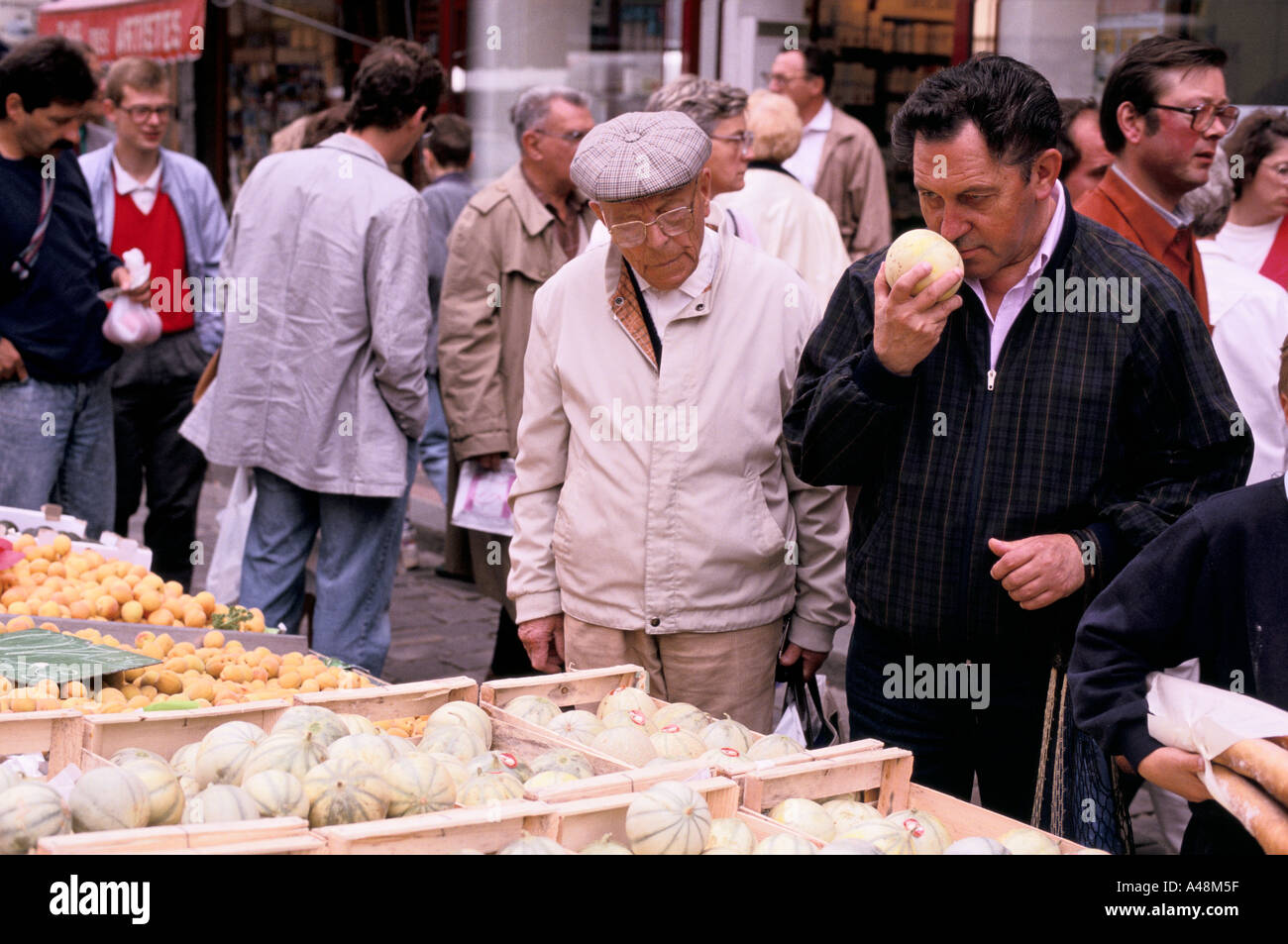 A man smelling a melon to test its ripeness Stock Photo Alamy