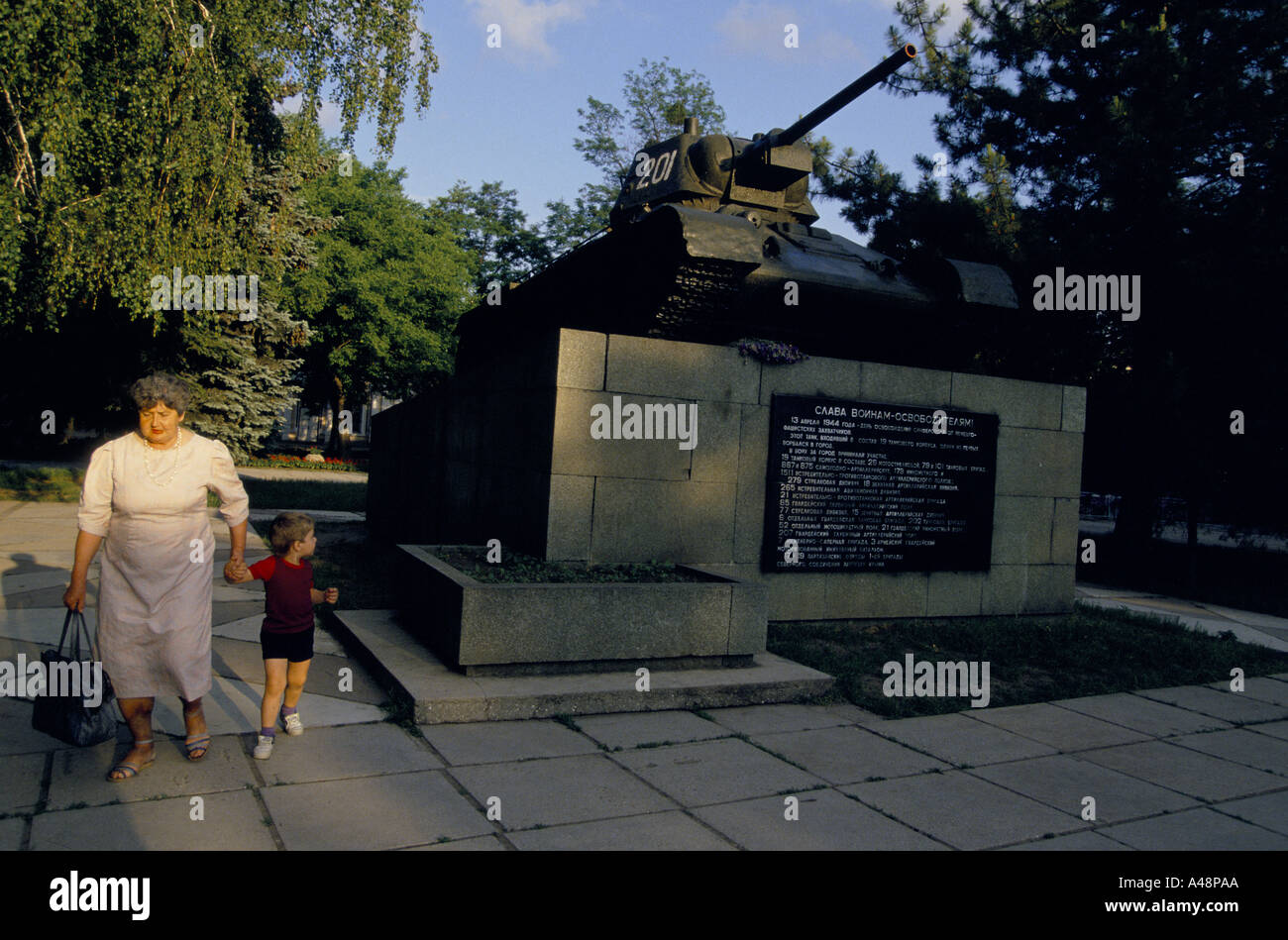 Woman walking with child past 2nd World War Memorial in Simferipol Stock Photo