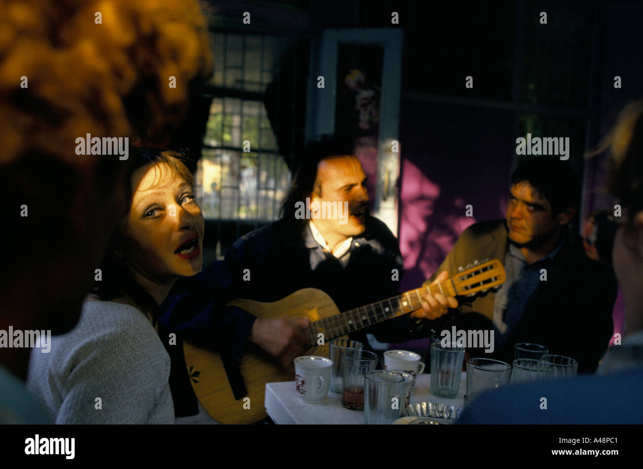 woman singing along with man playing guitar sitting in a cafe in simferopol Crimea ukraine Stock Photo