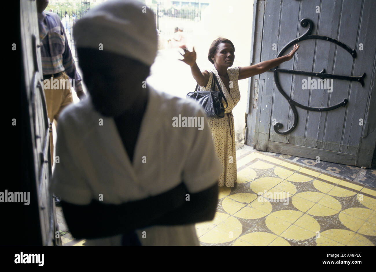 A woman praying on her knees at the Catholic cathedral  in Port au prince Haiti Stock Photo