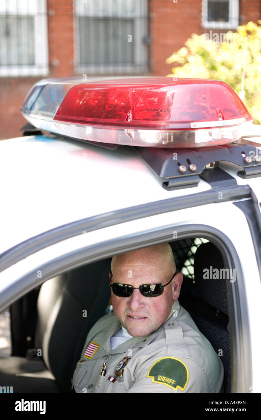 Policeman sitting in car Stock Photo