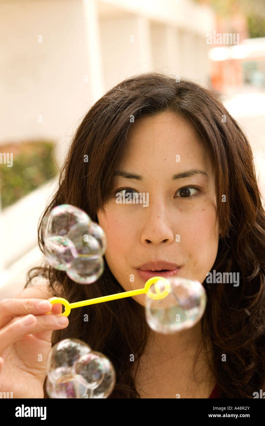 Young woman blowing soap bubbles Stock Photo