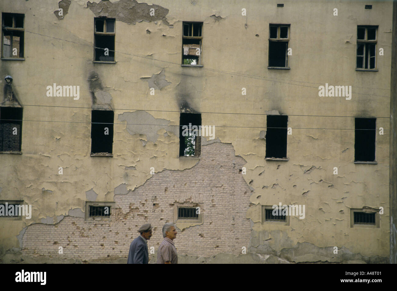 two men walking past burnt out building sarajevo july 1994 Stock Photo