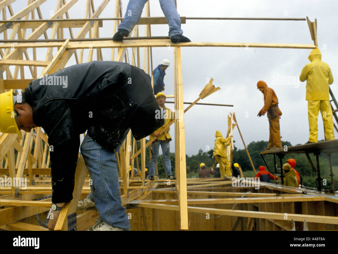 Construction workers fit prefabricated roof trusses whilst building a church Stock Photo