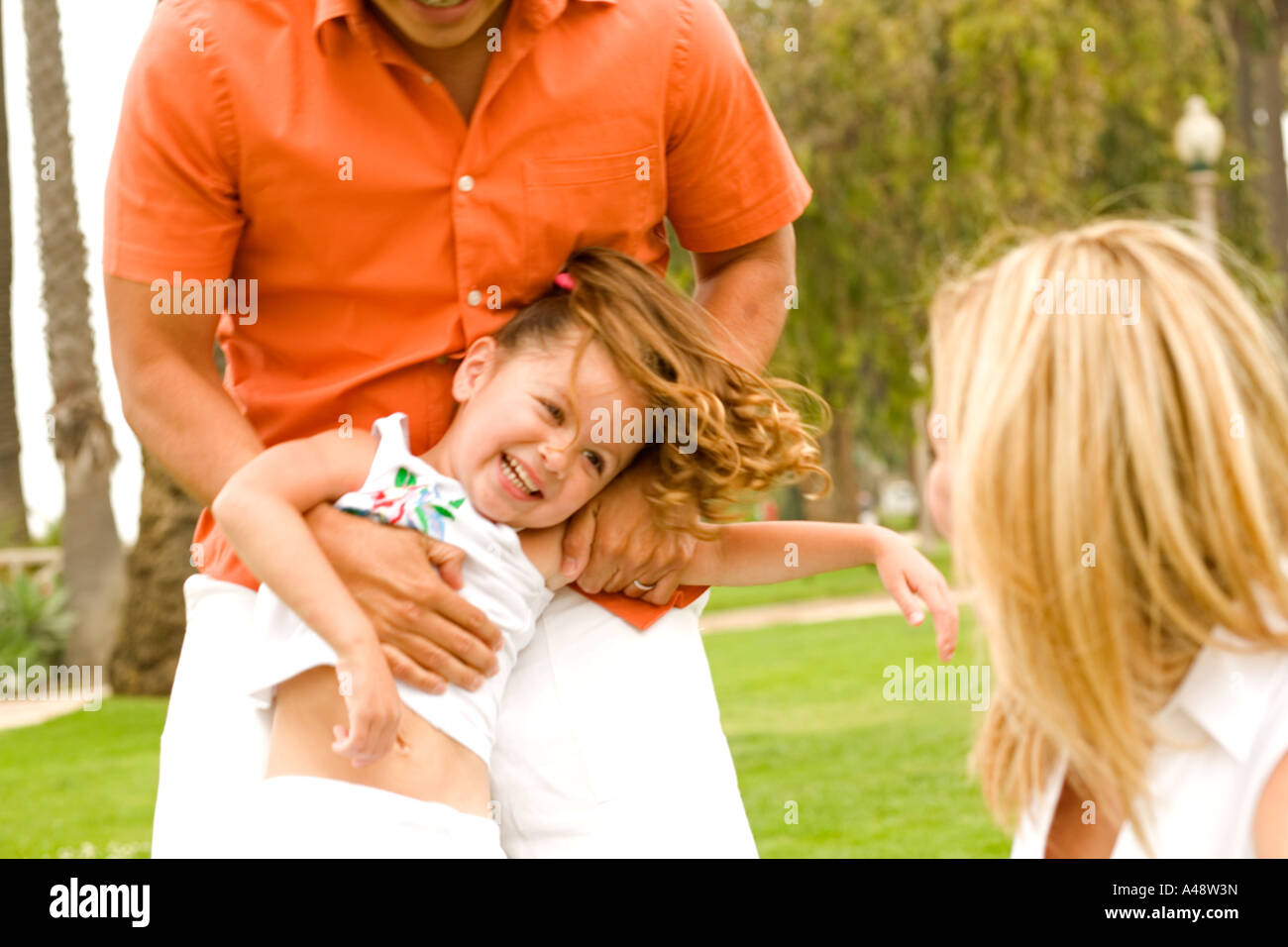 Parent playing with daughters Stock Photo