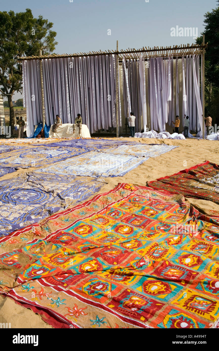 India Rajasthan crafts Sanganer textiles fabric drying in the sun on tall racks and on sand Stock Photo