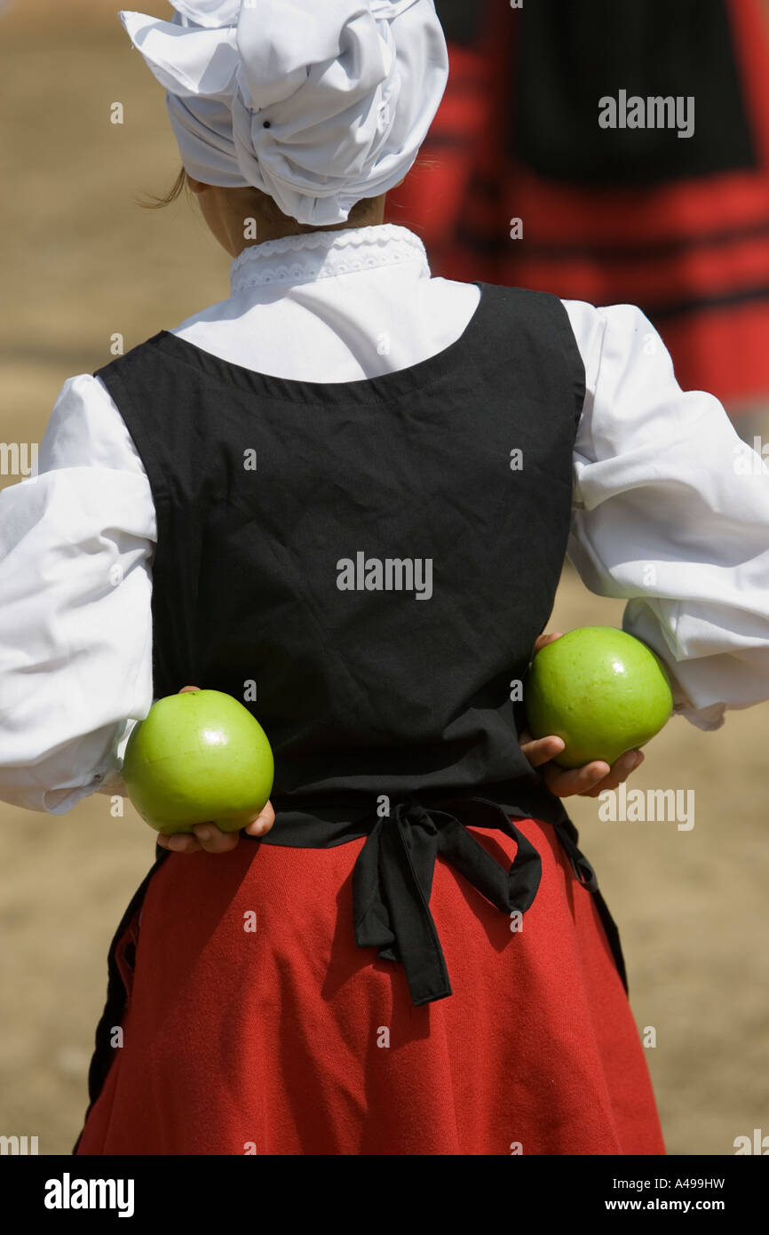 Basque girl performing Basque folk dance holding green apple in hand ...