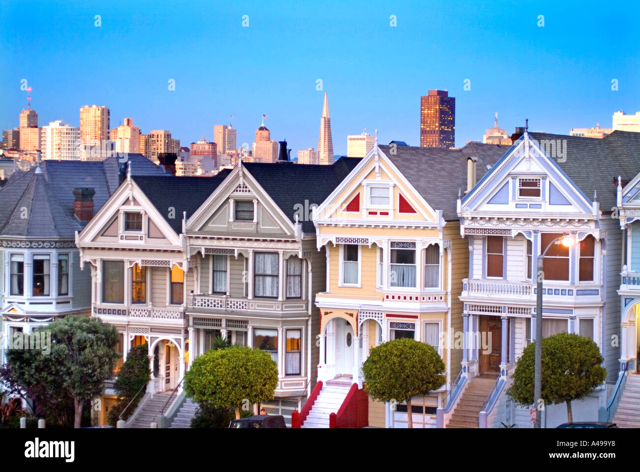 Post card row photo of the Victorian homes known as the Painted Ladies and the San Francisco skyline Stock Photo