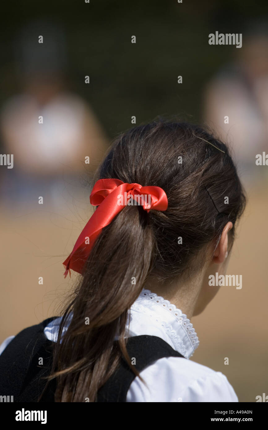 A beautiful girl in a white dress with a white ribbon bow in long dark hair  Stock Photo - Alamy
