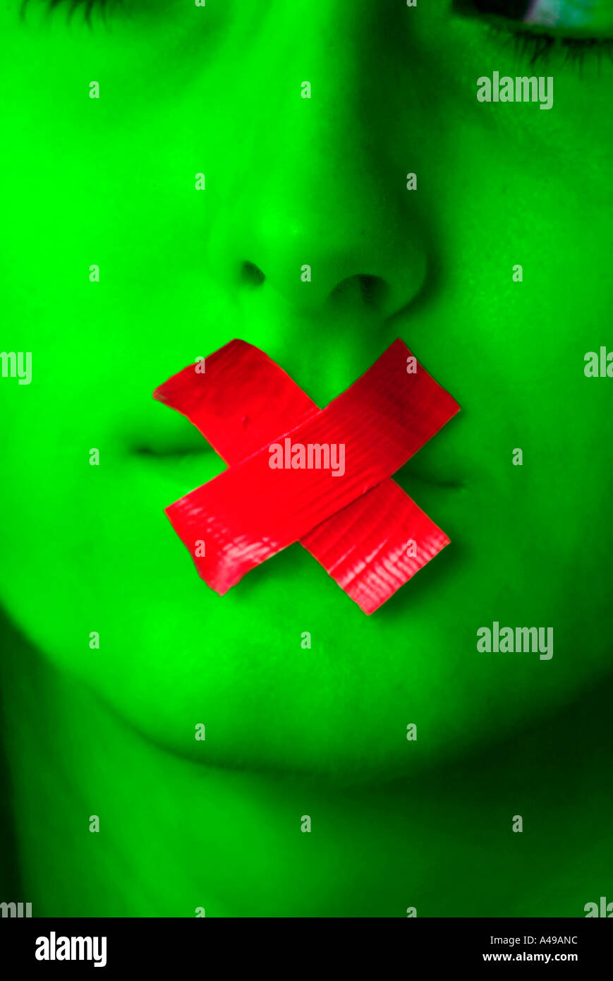 Red tape in the shape of an X over mouth of a girl Stock Photo