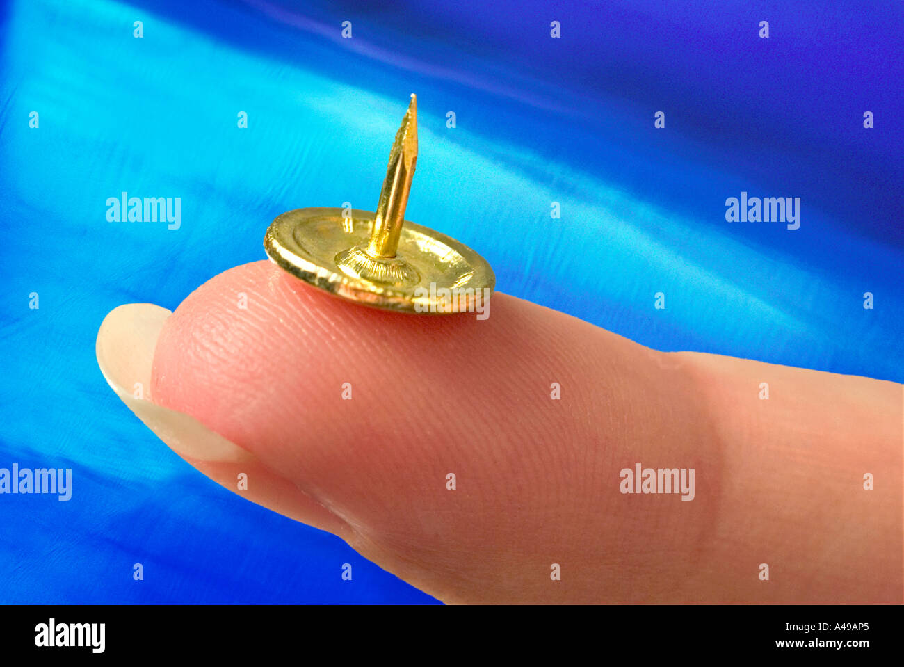 Brass tack resting on finger Stock Photo Alamy