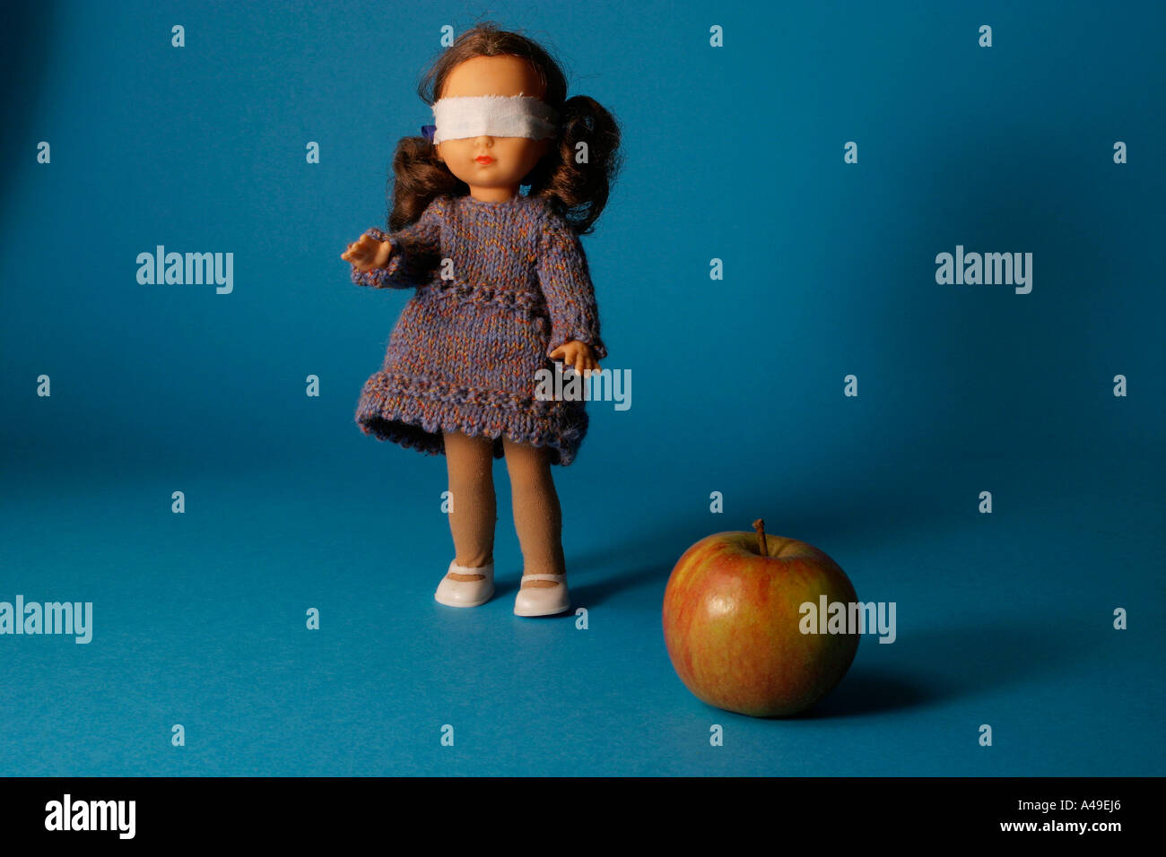 blindfolded doll with apple Stock Photo