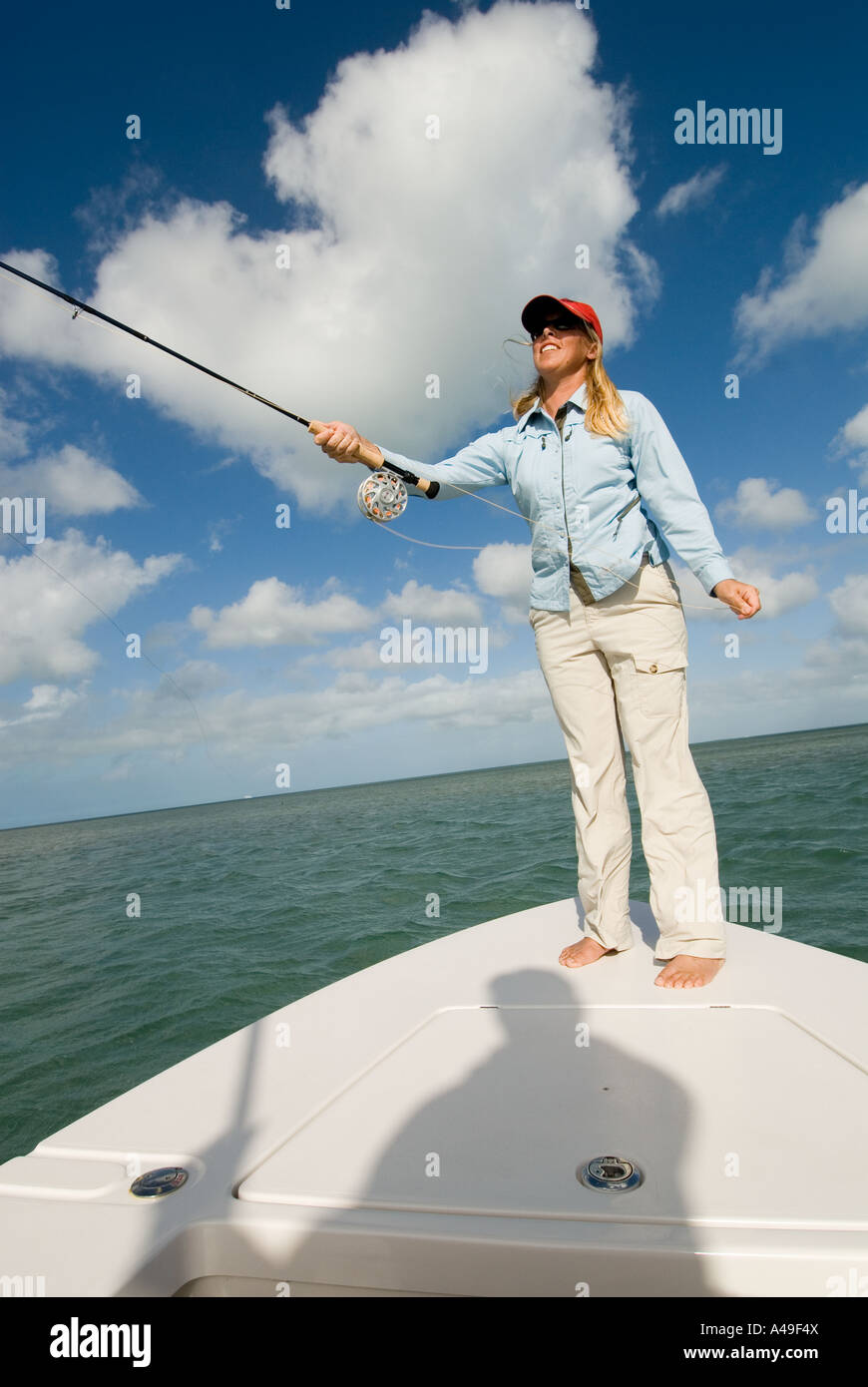USA Florida Keys Woman fisherman wearing red hat fly fishing from
