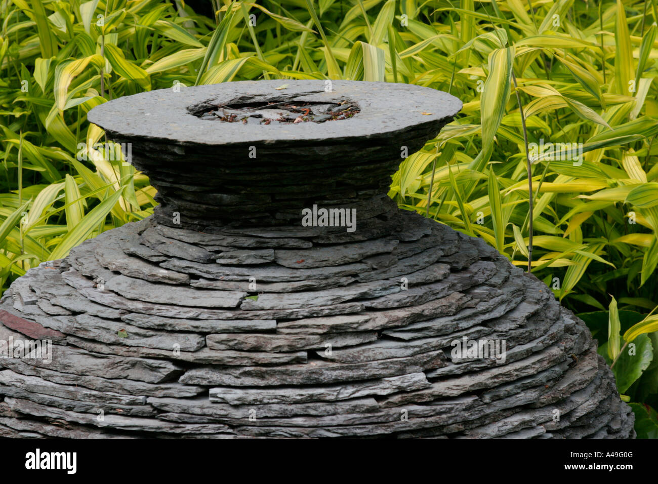 Stone slate garden ornament in front of bamboo Stock Photo