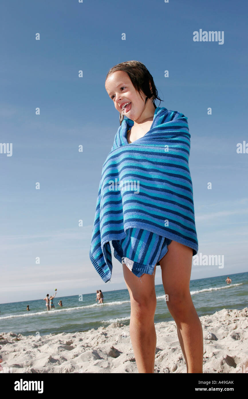 Young girl swathed in a towel just after a swim in the Baltic Sea Stock Photo