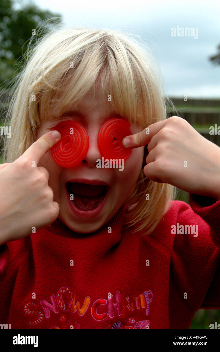 Kid holding jelly gums in front of his eyes Stock Photo Alamy