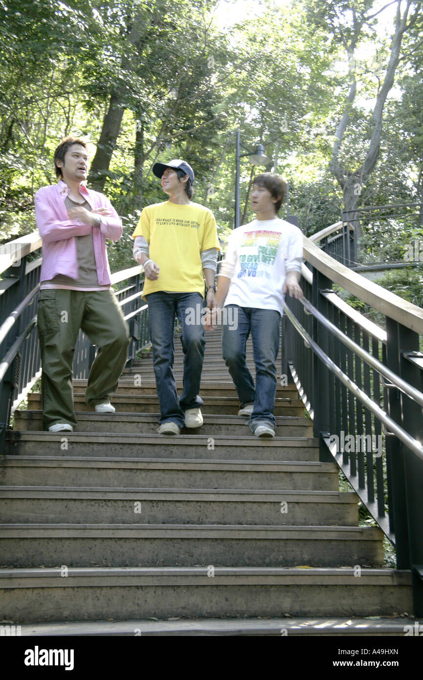 Low angle view of three young men walking down steps Stock Photo - Alamy